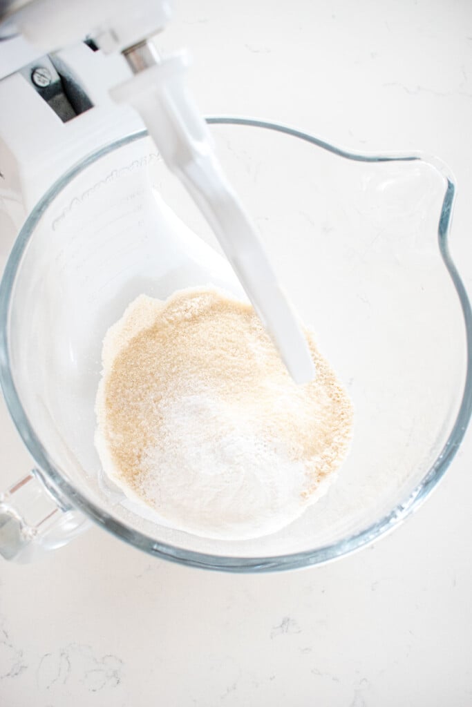 dry ingredients for citrus scones in a glass stand mixing bowl on a white marble counter.