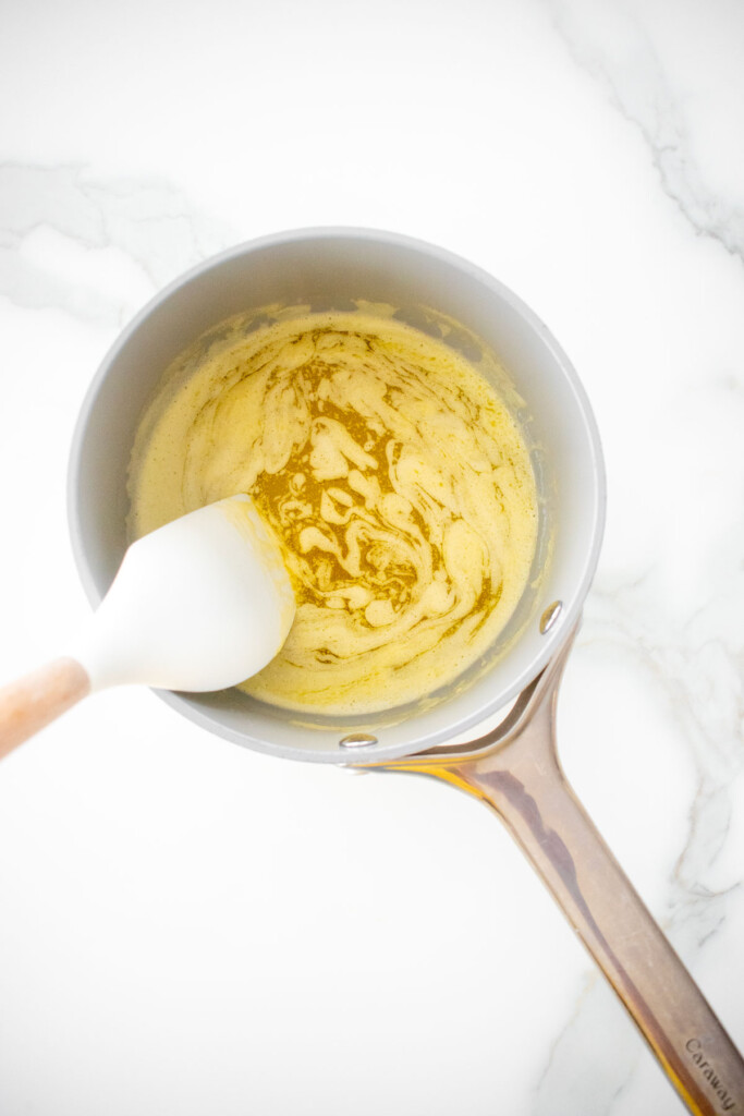 melted butter in a small saucepan on a white marble counter.