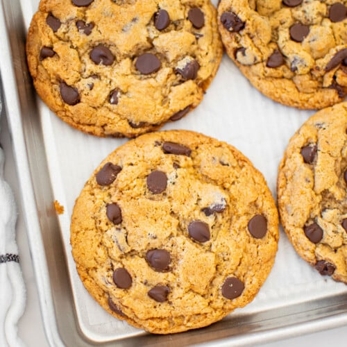 vegan banana chocolate chip cookies on a baking sheet on a marble counter.