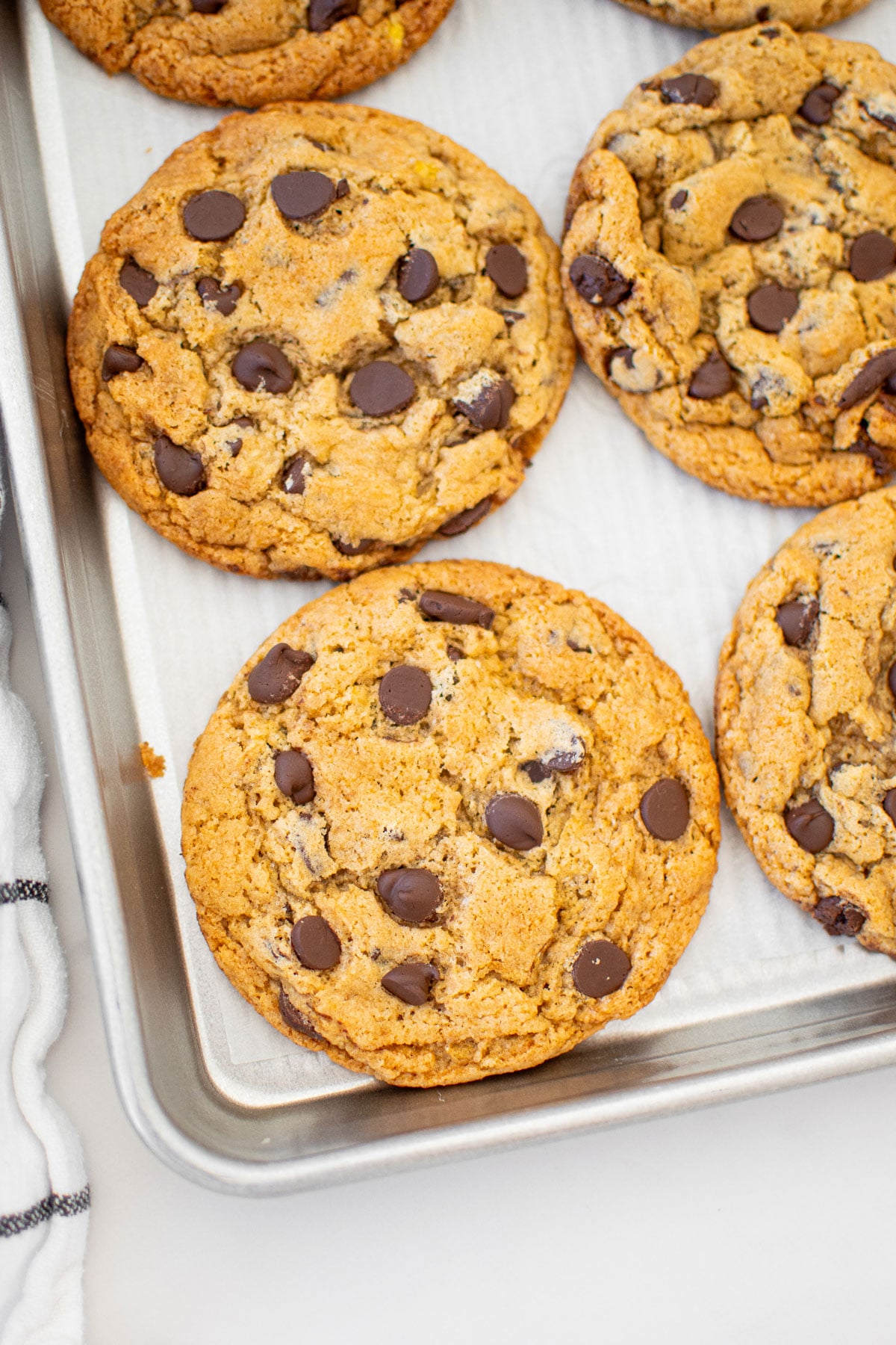 vegan banana chocolate chip cookies on a baking sheet on a marble counter.