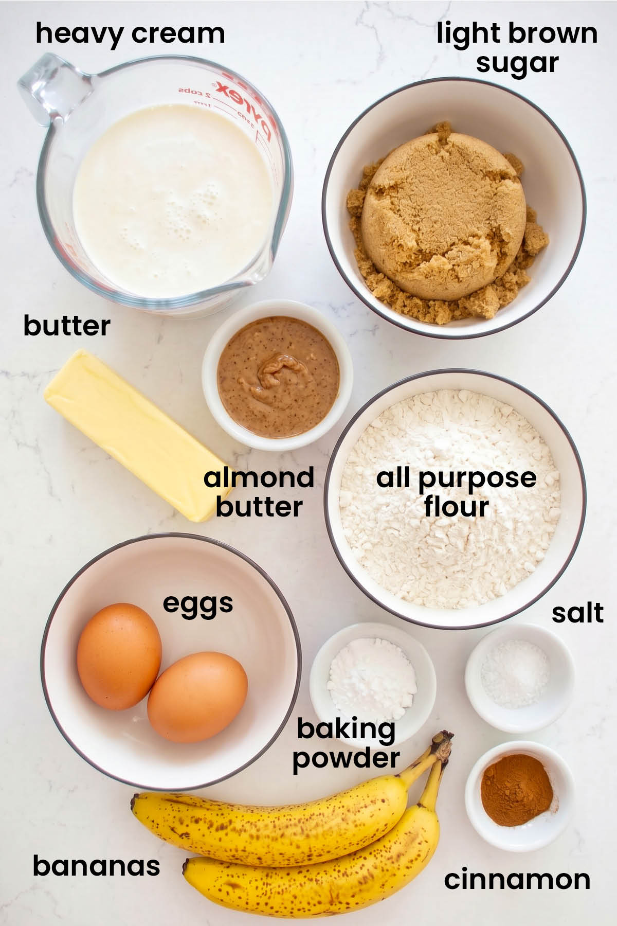 individual ingredients for almond butter banana bread laid out against a white background.