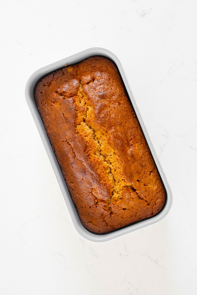 almond butter banana bread loaf on a white marble countertop.
