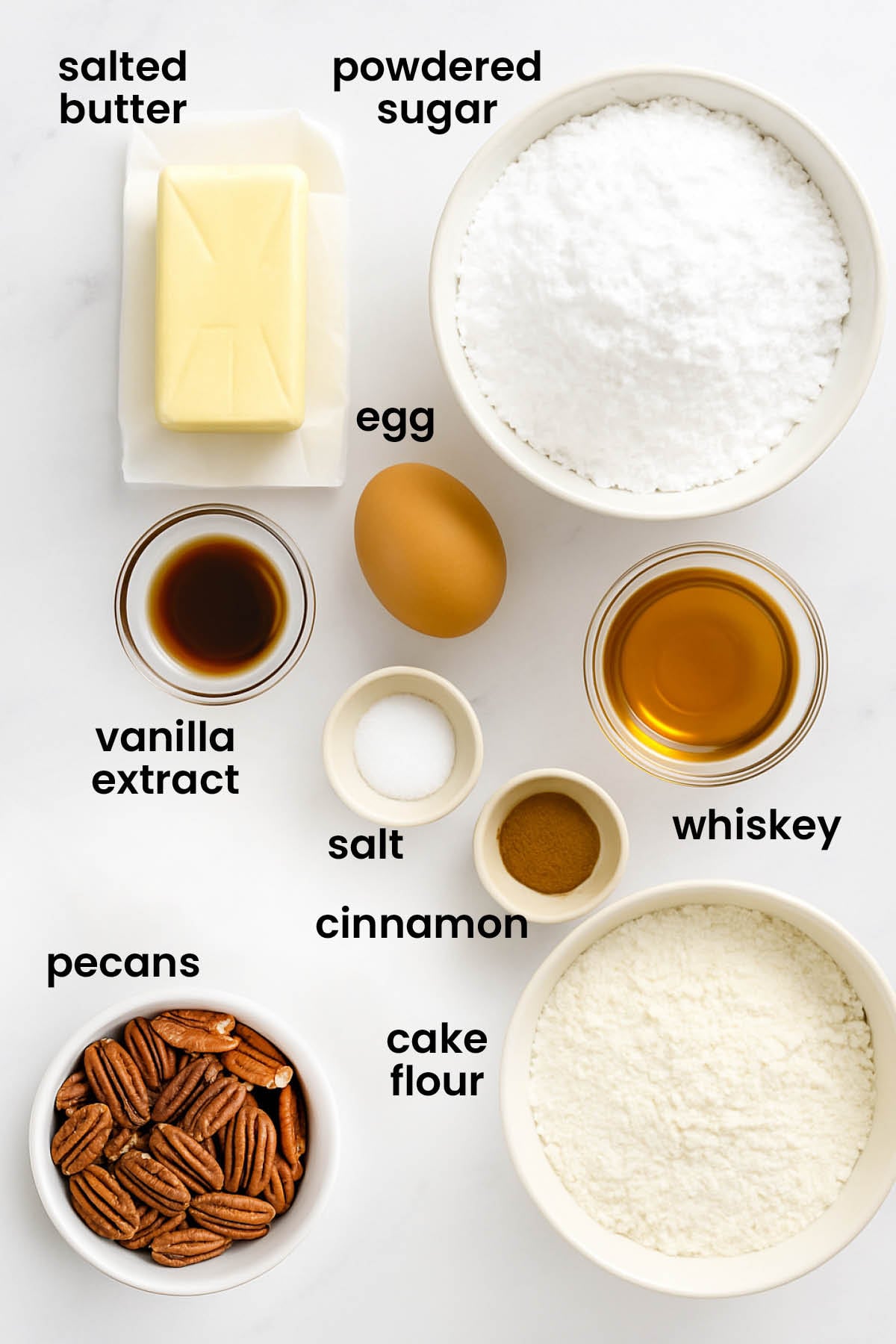 individual ingredients for Cinnamon Pecan Kourambiethes (Greek Butter Cookies) laid out against a white background.