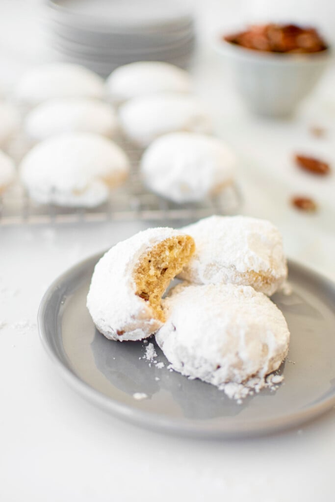 Cinnamon Pecan Kourambiethes (Greek Butter Cookies) on a gray plate on a white marble countertop.