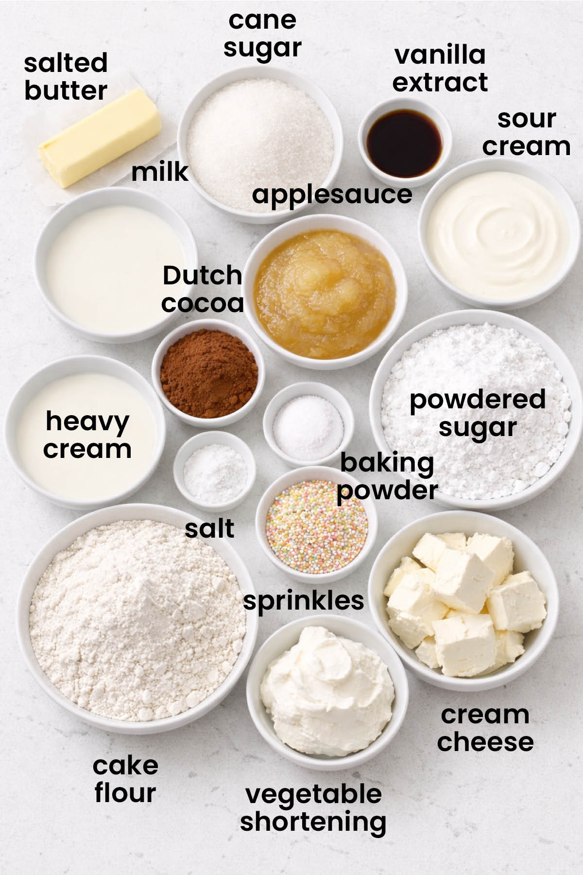 individual ingredients for eggless birthday cake laid out against a white background.