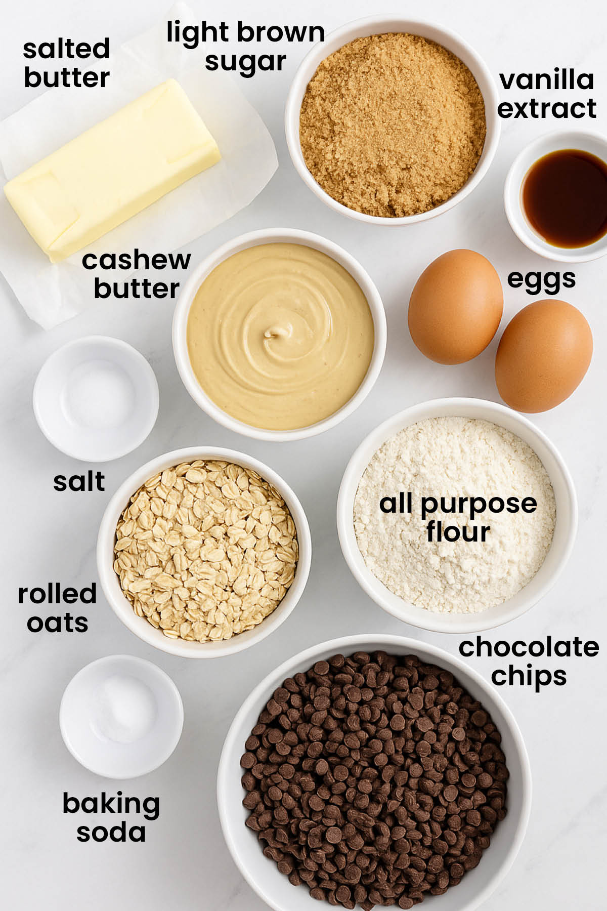 individual ingredients for oatmeal cashew butter chocolate chip cookies laid out against a white background.