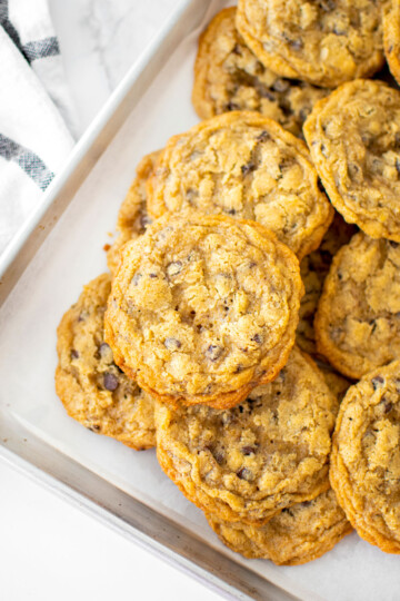 oatmeal cashew butter chocolate chip cookies on a baking sheet on a marble counter.