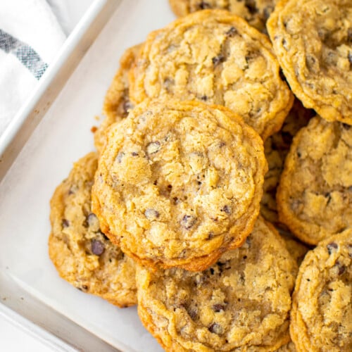 oatmeal cashew butter chocolate chip cookies on a baking sheet on a marble counter.