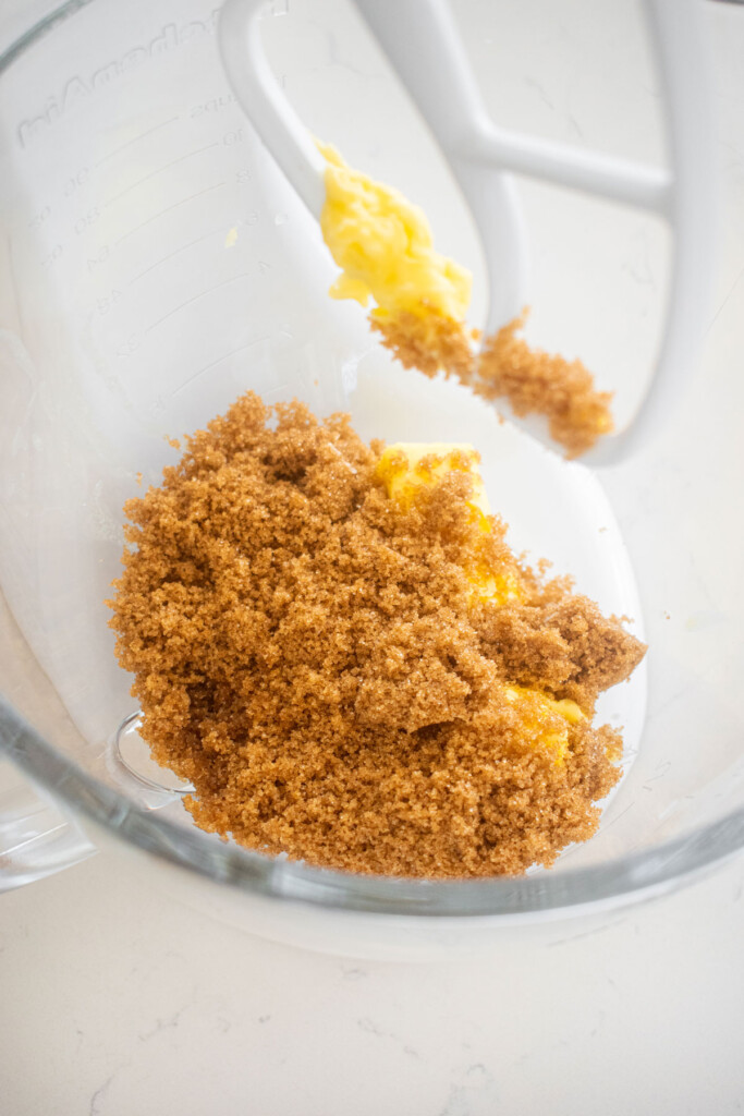 butter and brown sugar in a glass mixing bowl on a marble counte.r