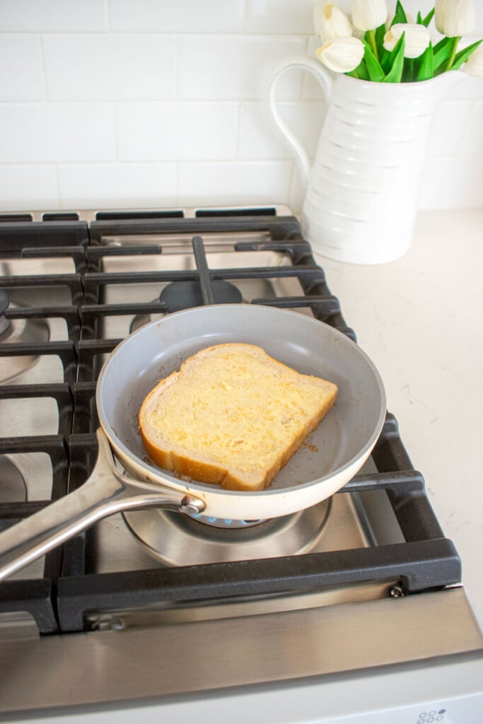 sourdough bread with garlic butter being toasted in a skillet on the stovetop.
