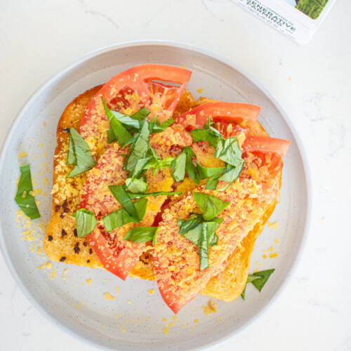 pizza toast without cheese on a gray plate on a marble countertop.