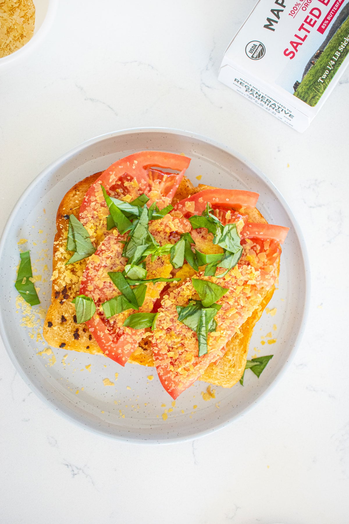 pizza toast without cheese on a gray plate on a marble countertop.