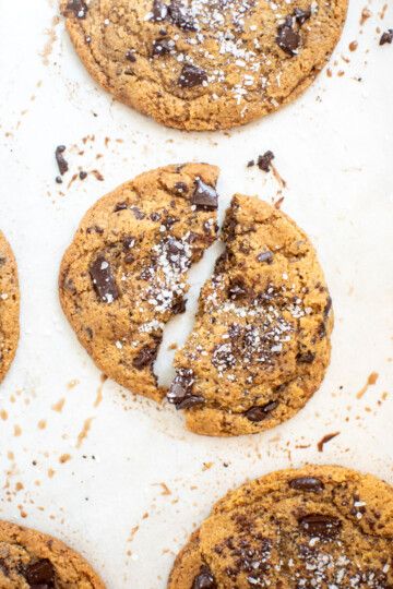 eggless sea salt dark chocolate chunk cookie with flaky sea salt broke in half on a baking sheet.