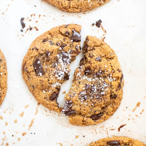 eggless sea salt dark chocolate chunk cookie with flaky sea salt broke in half on a baking sheet.