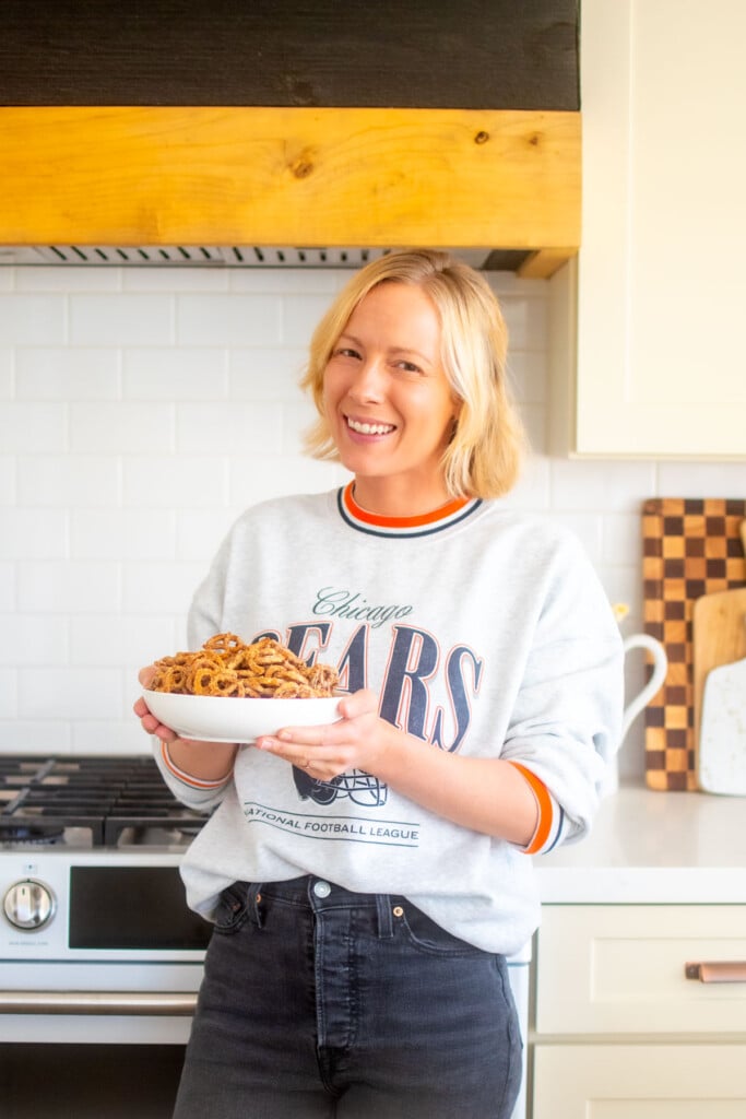 woman holding a bowl of garlic ranch pretzels with white cheddar in the kitchen.