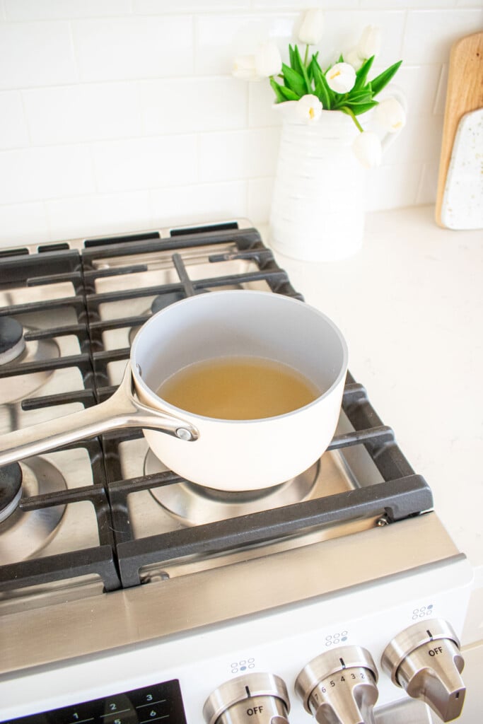 simple syrup being made in a small pot on the stovetop.