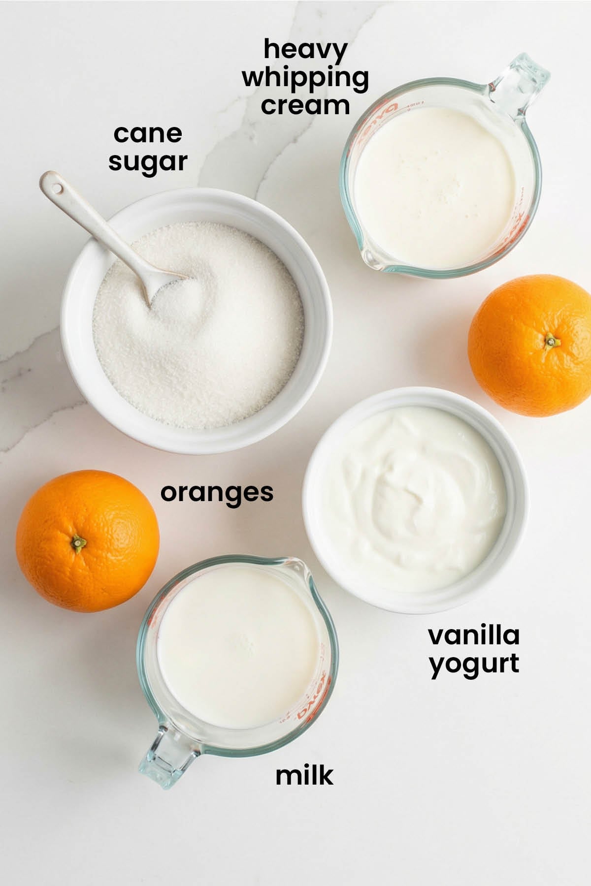 individual ingredients for orange creamsicle popsicles laid out against a white background.