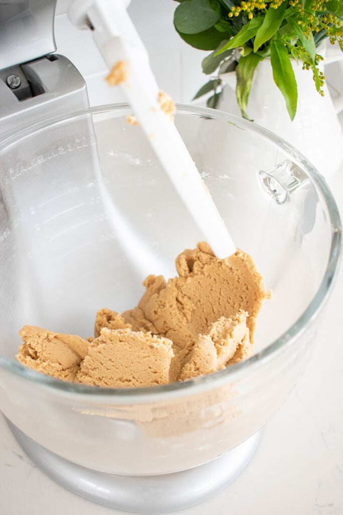 cookie dough mixed together in a glass mixing bowl on the countertop.