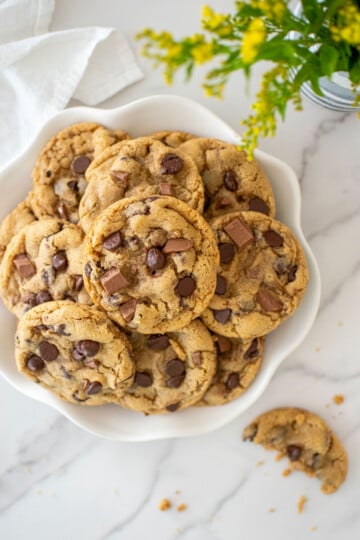 plate of coffee creamer cookies on a white marble countertop.