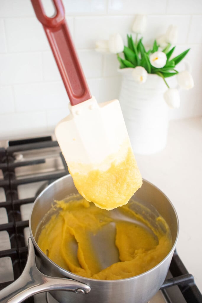 homemade custard being cooked on the stovetop in a pot.