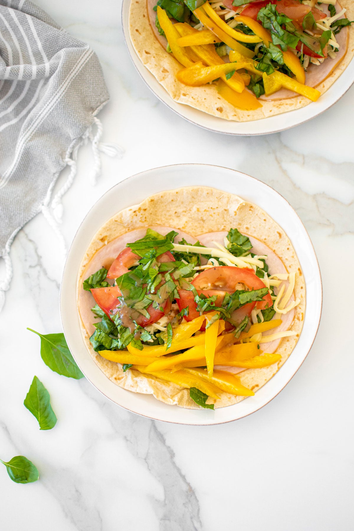 tomato basil soft tacos on a plate on a marble countertop.
