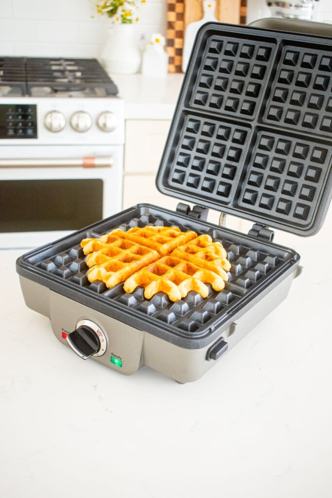 waffle iron with a golden brown eggless banana waffle.