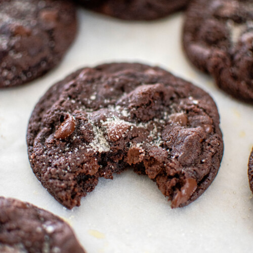 eggless chocolate chocolate chip cookie on a baking sheet with a bite taken out.