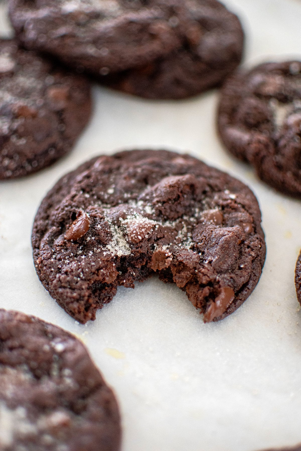 eggless chocolate chocolate chip cookie on a baking sheet with a bite taken out.