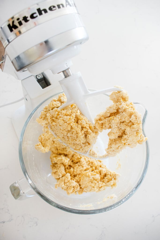 everything bagel scones dough in a glass mixing bowl on a white countertop.