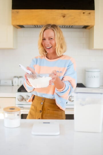 woman holding a bowl of homemade organic cake flour in the kitchen.