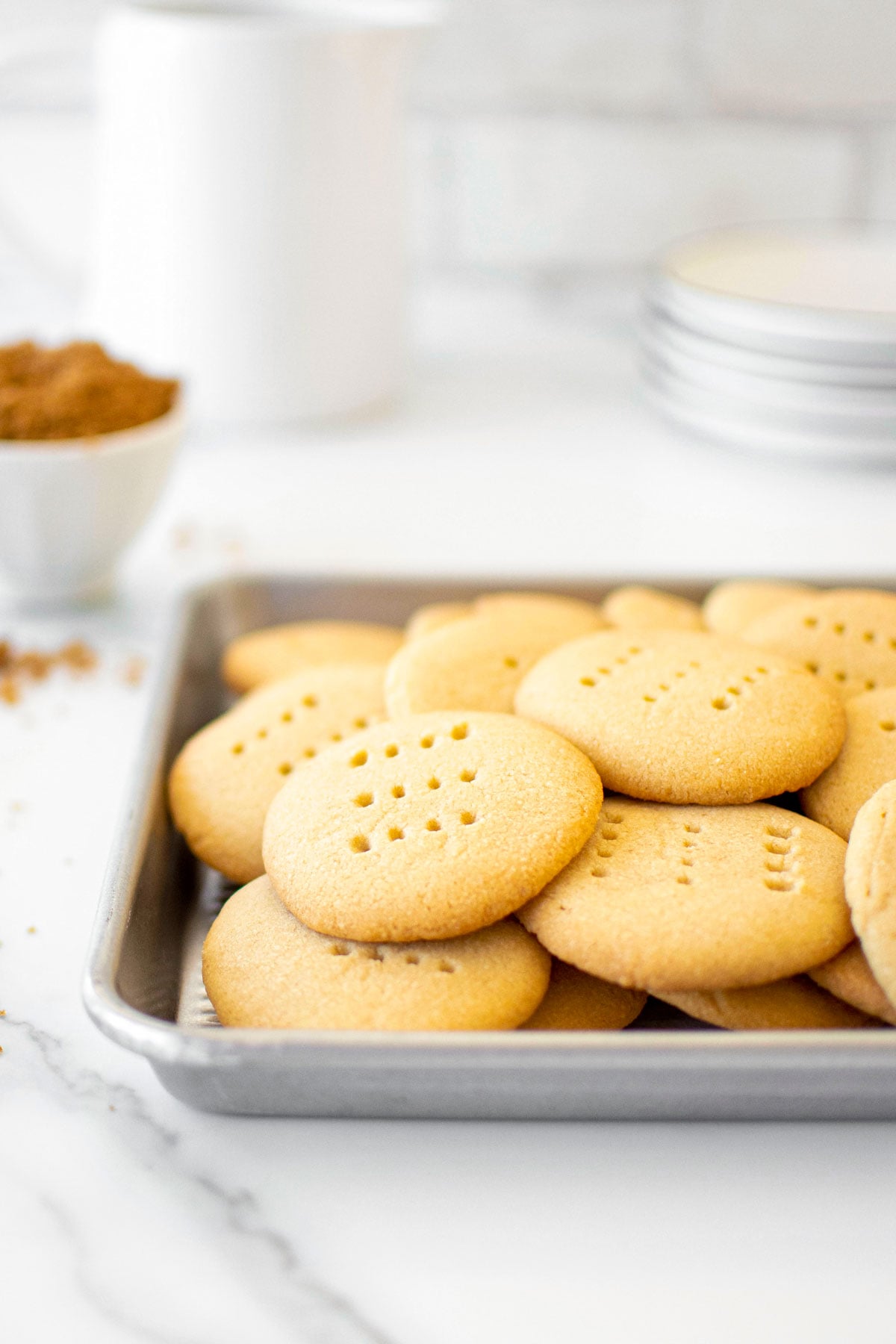 brown sugar shortbread cookies on a baking sheet on a white marble counter.