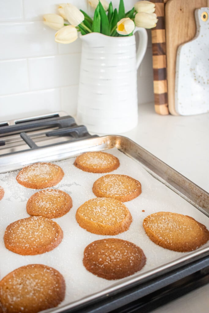 baked brown sugar shortbread cookies on a baking sheet cooling on top of an oven.