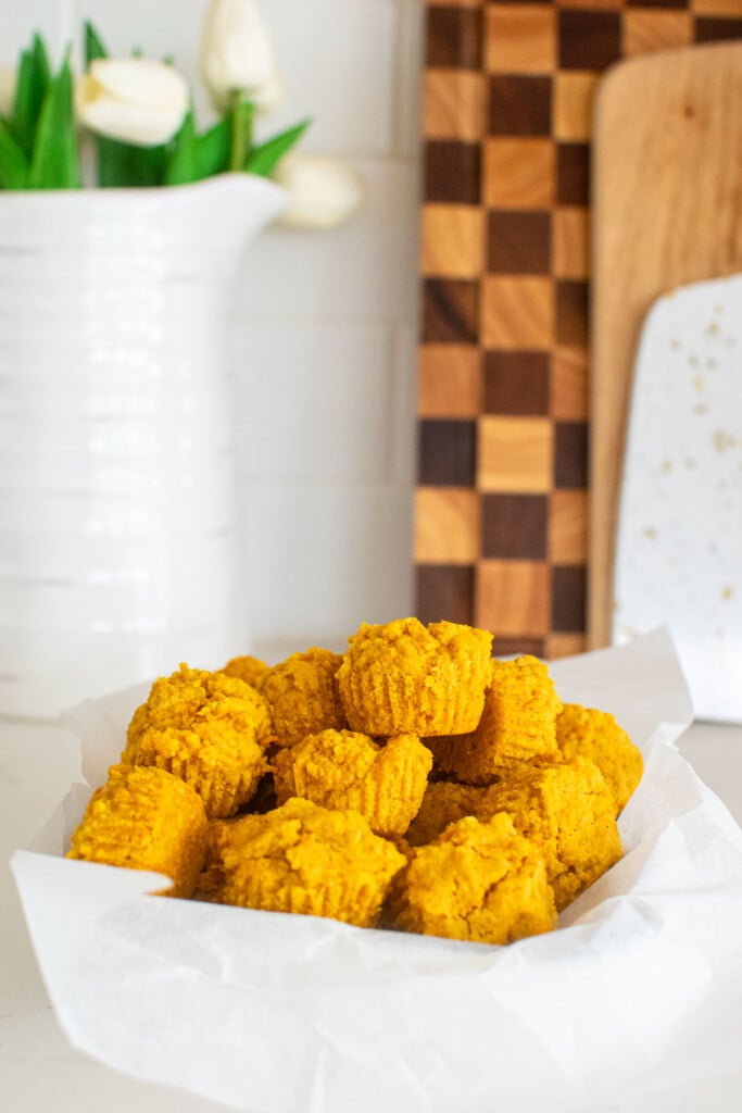 healthy dog muffins in a parchment paper lined serving dish on the kitchen counter.