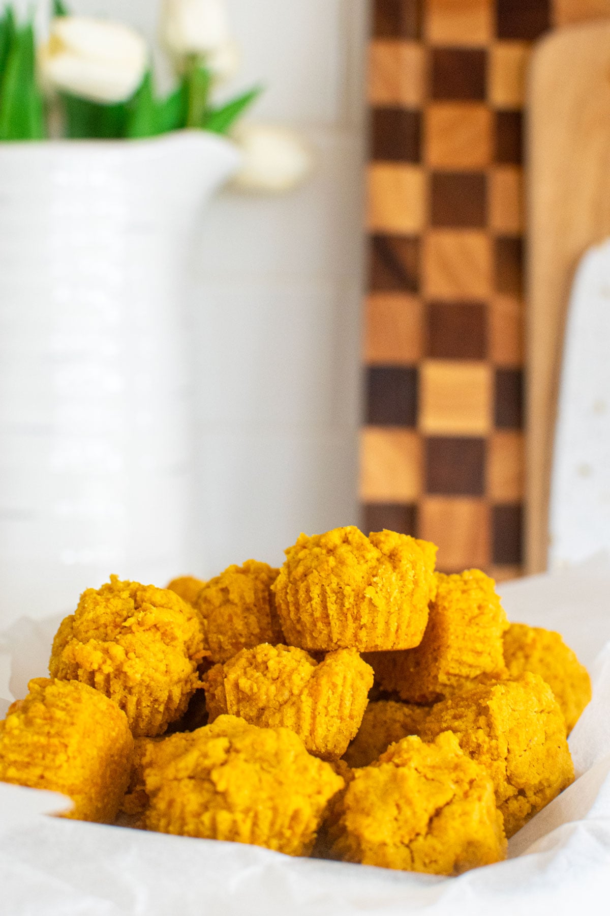 healthy dog muffins in a parchment paper lined serving dish on the kitchen counter.