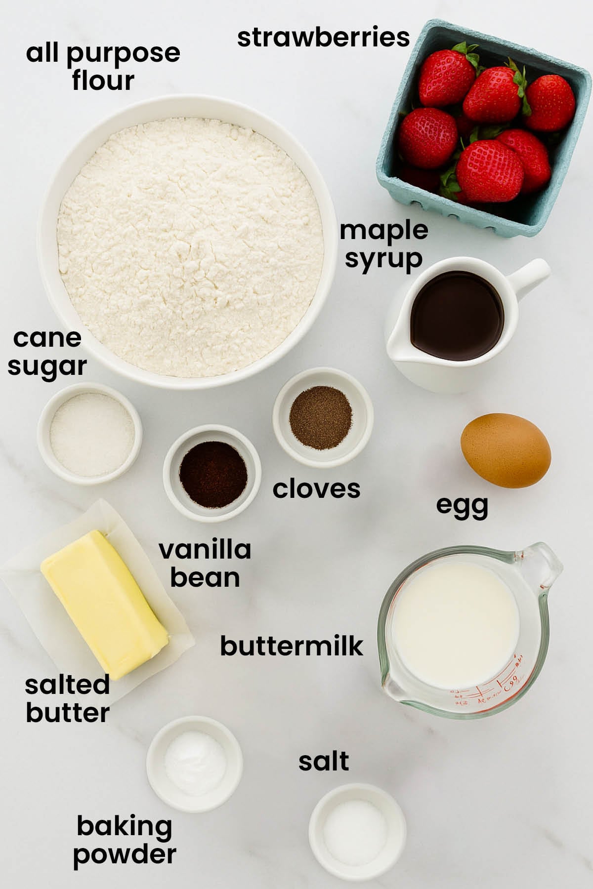 individual ingredients for homemade buttermilk pancakes laid out against a white background.