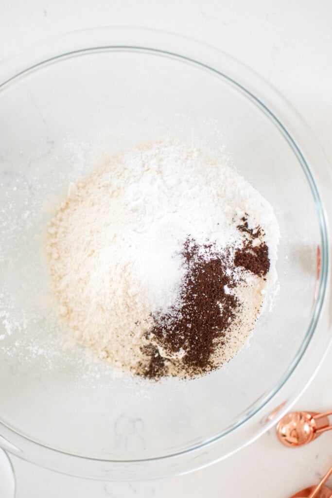 dry ingredients for homemade buttermilk pancakes in a glass mixing bowl on a white marble counter.