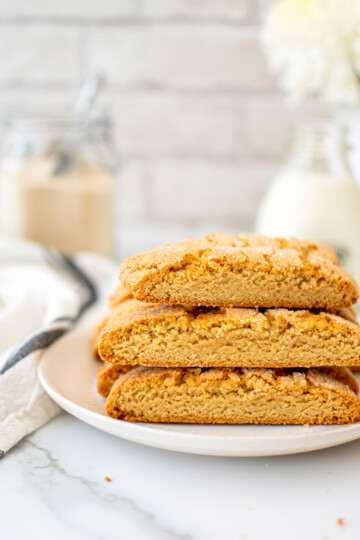 kamut flour biscotti on a plage on a white marble counter with fresh flowers.