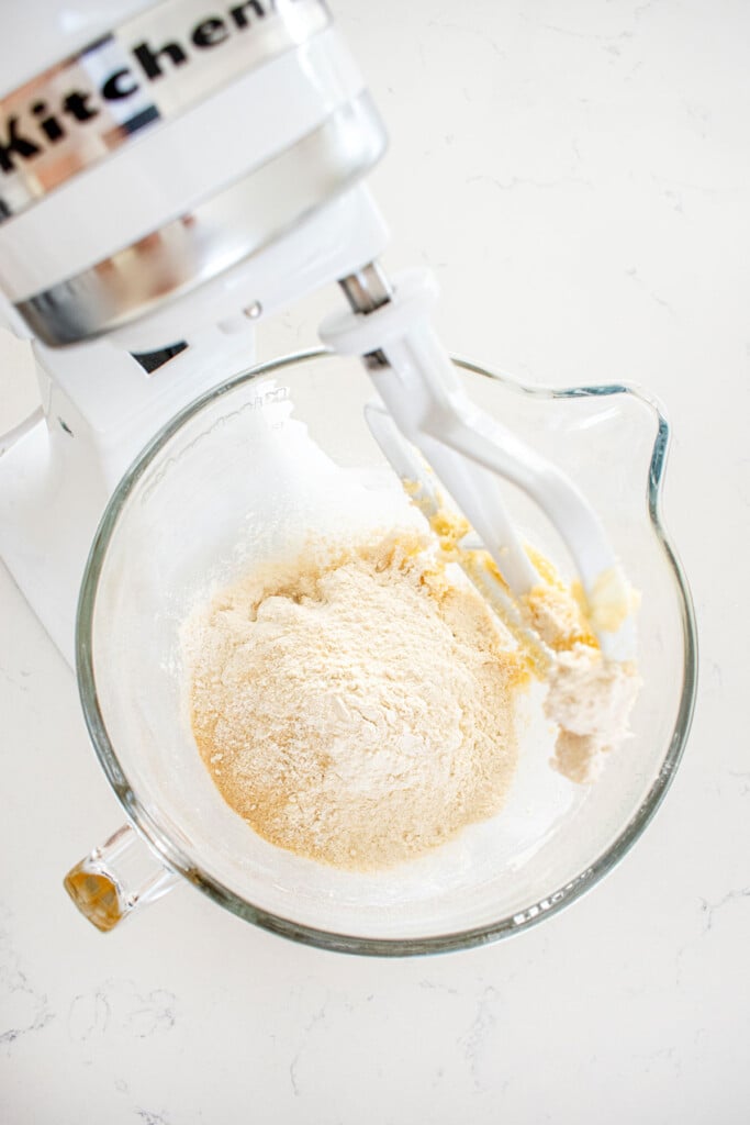 ingredients for kamut flour biscotti cookie dough in a glass mixing bowl on a marble counter.