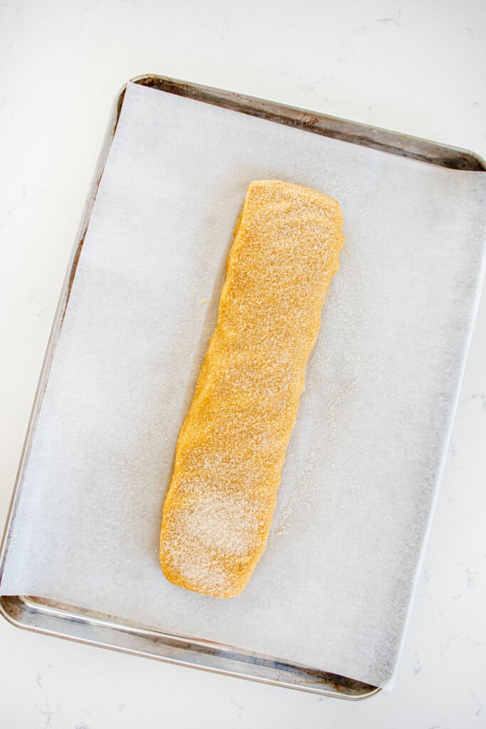 kamut flour biscotti cookie dough log on a baking sheet on a marble counter.