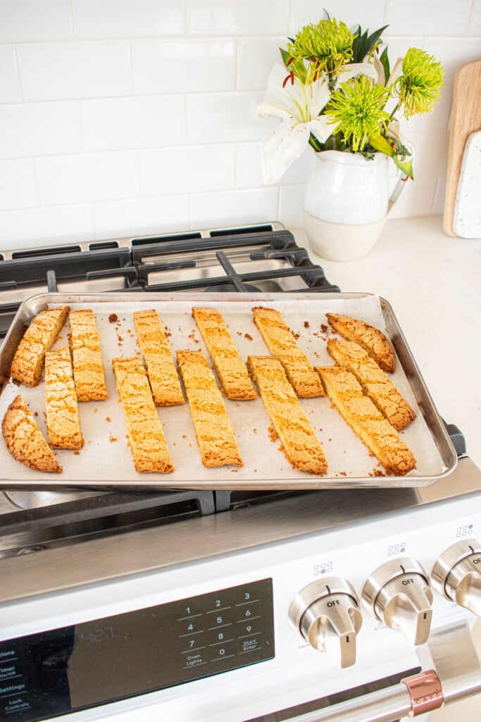 kamut flour biscotti on a baking sheet cooling on top of an oven.
