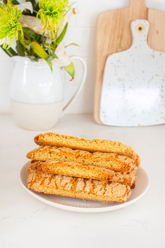 kamut flour biscotti on a plage on a white marble counter with fresh flowers.