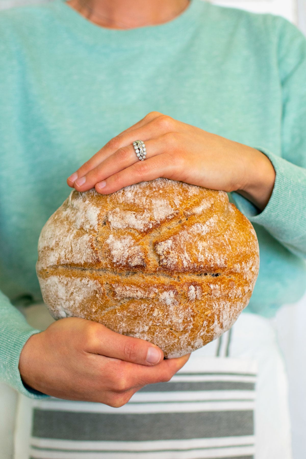 woman holding loaf of sourdough bread.