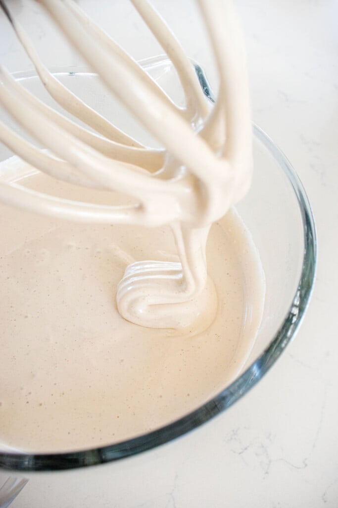 homemade pumpkin spice marshmallows in a stand mixer on a marble countertop.