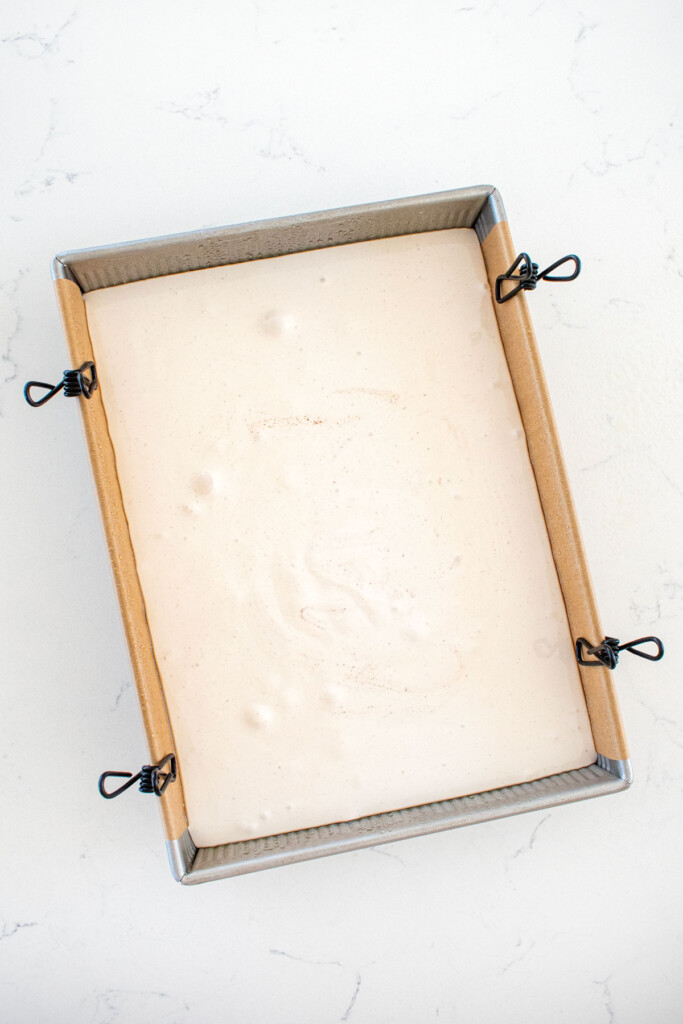 homemade pumpkin spice masrhmallows in a baking pan on a marble countertop.