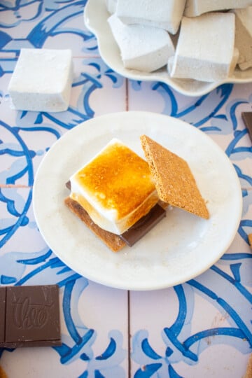 homemade pumpkin spice marshmallows toasted on a smore on a plate.