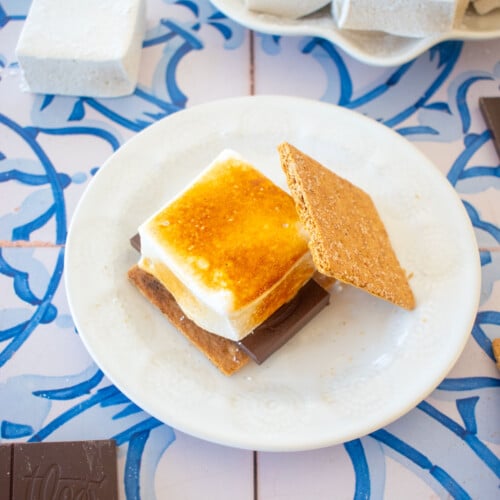 homemade pumpkin spice marshmallows toasted on a smore on a plate.