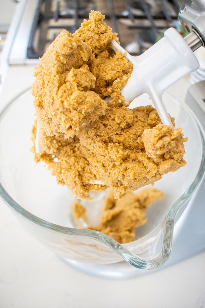 rye chocolate chip cookie dough in a glass mixing bowl on a white marble counter.