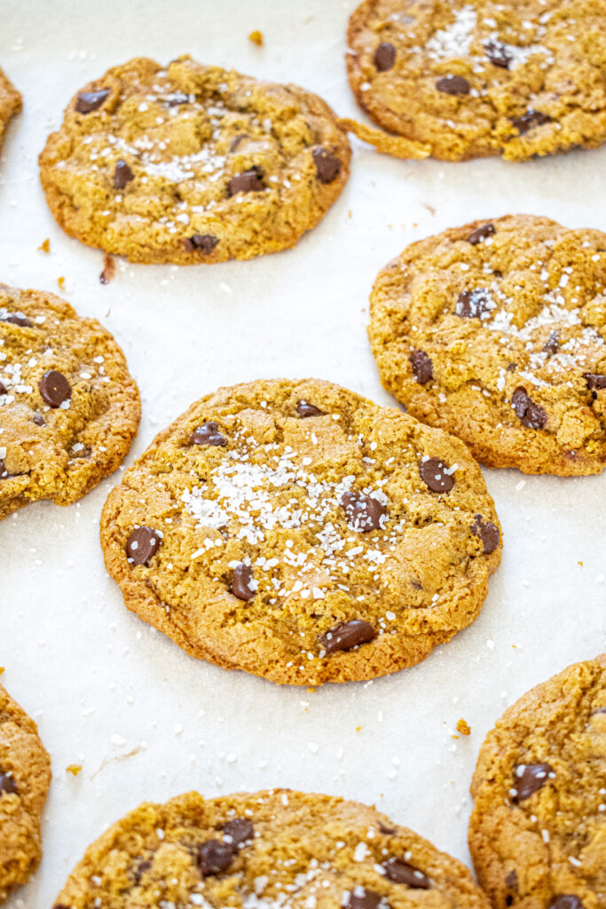 rye chocolate chip cookies with flaky sea salt on a baking sheet.