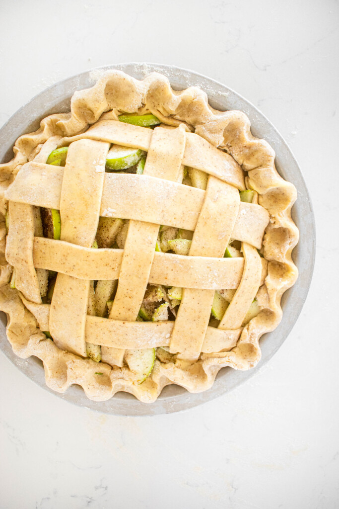 lattice vanilla bean apple pie on a white marble counter.