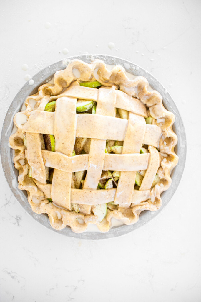 vanilla bean apple pie brushed with french vanilla coffee creamer on a white marble counter.